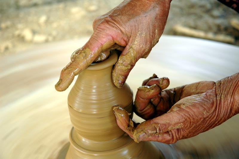 Artisans in Thanh Ha pottery village are shaping products on a potter's wheel.